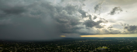 Landscape of dark ominous clouds forming on stormy sky during heavy thunderstorm over rural town areaの写真素材