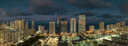 Night urban landscape of downtown district in Sunny Isles Beach city in Florida, USA. Skyline with brightly illuminated high skyscraper buildings in modern american megapolisの写真素材