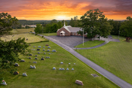 Old cemetery with grave stones on green grass lawn in American countryside town. Concept of deathの写真素材