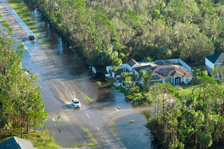 Aerial view of flooded street after hurricane rainfall with driving cars in Florida residential area. Consequences of natural disasterの写真素材