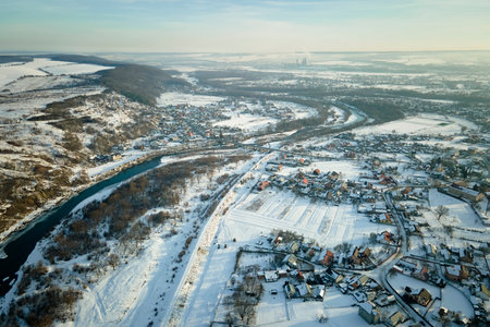Aerial view of residential houses with snow covered roofops in suburban rural town area in winterの写真素材