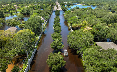 Flooded Florida street with stuck car after hurricane Debby rainfall surrounded with water. Consequences of natural disasterの写真素材