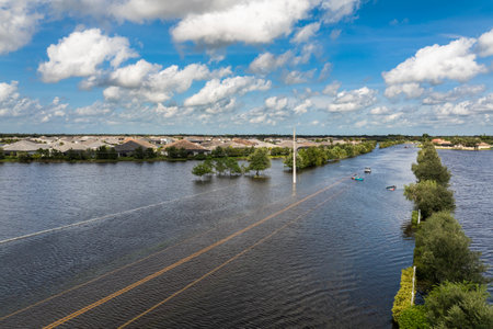Flooded Florida street with stuck car after hurricane Debby rainfall surrounded with water. Consequences of natural disasterの写真素材