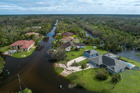 Heavy flood with high water surrounding residential houses after hurricane Ian rainfall in Florida residential area. Consequences of natural disasterの写真素材