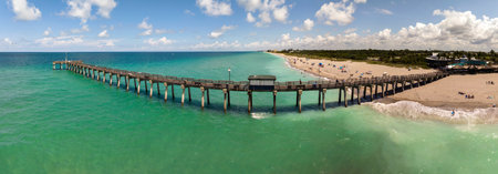 Idyllic summer day over sandy beach at Venice fishing pier in Florida. Summer seascape with surf waves crashing on sea shoreの写真素材