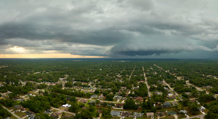 Landscape of dark ominous clouds forming on stormy sky before heavy thunderstorm over rural town areaの写真素材