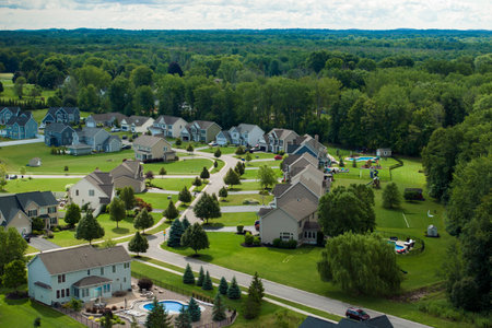Low-density two story private homes in rural residential suburbs outside of Rochester, New York. Upscale suburban houses with large lot size and green grassy lawns in summer seasonの写真素材