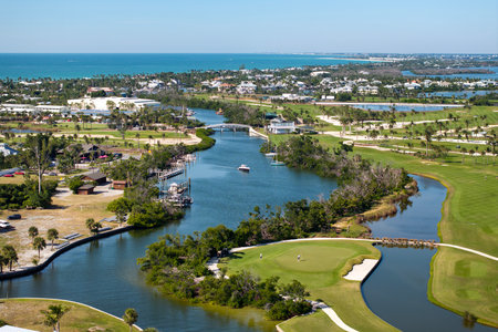 Premium housing development in the USA. Expensive waterfront houses between green palm trees in Boca Grande, small town on Gasparilla Island in southwest Floridaの写真素材