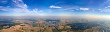 Aerial view of farm fields and distant scattered houses in rural area
