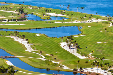 Oceanfront golf course in sunny Florida. Outdoor sport grounds with green grass lawns in Boca Grande, small town on Gasparilla Islandの写真素材