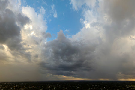 Heavy rain falling down from stormy clouds over rural Florida suburbs. Thunderstorm on dark sky. Moving and changing cloudscape weatherの写真素材