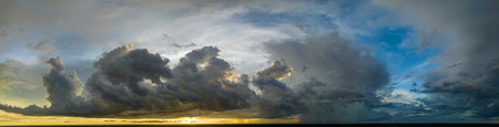 Cumulonimbus clouds forming before thunderstorm on evening sky. Changing stormy cloudscape weather at sunsetの写真素材