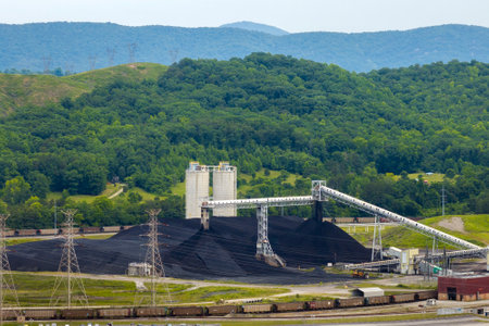 Coal-fired power plant producing electricity. Large pile of coal fossil fuel used for energy...