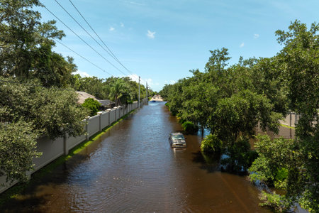 Hurricane rainfall flooded road. Drowned car on city street in Florida residential area. Consequences of hurricane natural disasterの写真素材