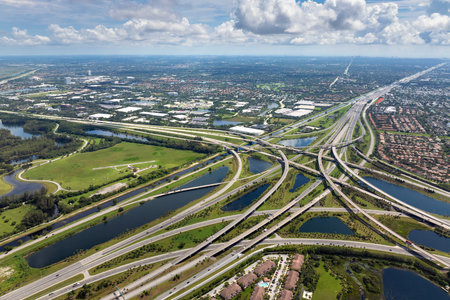 View from above of USA transportation infrastructure. American freeway intersection with fast driving cars and trucks in Miami, Floridaの写真素材