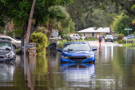 Hurricane rainfall flooded road. Drowned cars on city street in Florida residential area. Consequences of hurricane natural disasterの写真素材