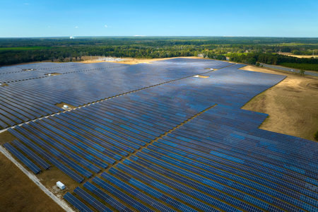 Aerial view of big sustainable electric power plant with many rows of solar photovoltaic panels for producing clean electrical energy. Renewable electricity with zero emission conceptの写真素材