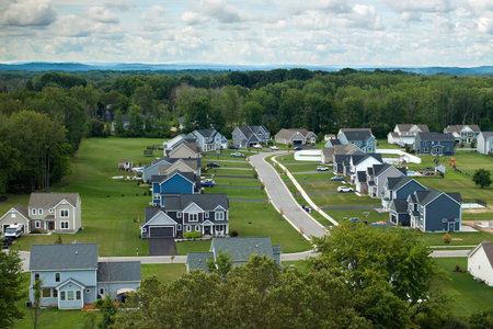 Aerial view of private residential houses in rural suburban sprawl area in Rochester, New York. Upscale suburban homes with large backyards and green grassy lawns in summer seasonの写真素材