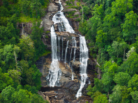Whitewater Falls with falling down clear water from rocky boulders between green lush woods in Nantahala National Forest, North Carolina, USAの写真素材