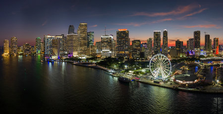 American urban landscape at night. Skyviews Miami Observation Wheel at Bayside Marketplace with reflections in Biscayne Bay water and high illuminated skyscrapers of Brickell, citys financial centerの写真素材