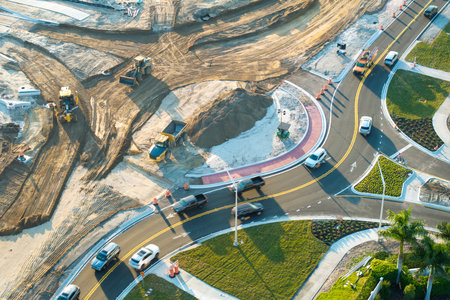 Driving traffic cars at roundabout intersection under construction. Building traffic circle on American road with moving carsの写真素材