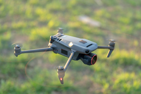 Drone aircraft with blurred fast rotating propellers and video camera flying in airの写真素材