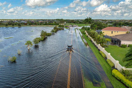 Flooded Florida street with stuck car after hurricane Debby rainfall surrounded with water. Consequences of natural disasterの写真素材