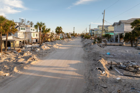 Heaps of debris rubbish on street side near severely damaged by hurricane Milton houses in Florida residential area on Manasota Key in Englewood. Consequences of natural disasterの写真素材
