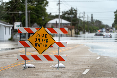 Hurricane Debby flooded street with road closed sign blocking driving of cars in Sarasota, Florida. Safety of transportation during natural disaster conceptの写真素材