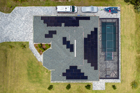 Solar photovoltaic panels mounted on house roof for producing clean ecological electric energy. Investing in renewable electricity for retirement income conceptの写真素材
