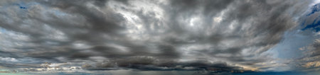Stormy cumulus clouds forming during heavy thunderstorm on dark sky. Moving and changing cloudscape weatherの写真素材