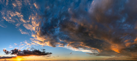 Sunset sky with bright colorful orange and yellow clouds. Panoramic skyscapeの写真素材