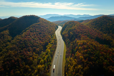 View from above of I-40 freeway in North Carolina heading to Asheville through Appalachian mountains in golden fall season with fast driving trucks and cars. Interstate transportation conceptの写真素材