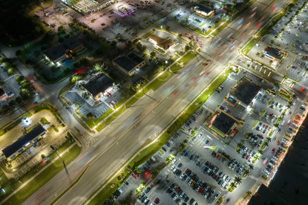 American wide road and strip mall plaza in North Port, Florida. Illuminated town traffic with driving cars at night. USA transportation infrastructure conceptの写真素材