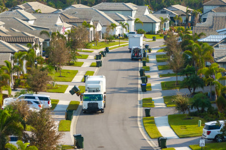 Automated modern garbage collector truck loading waste on Florida town street. Municipal servicesの写真素材