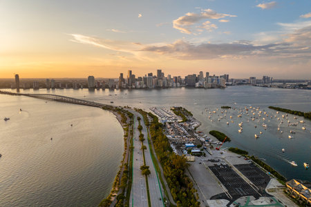 Biscayne Bay harbor with many yachts and fishing boats in Miami, Florida. Enjoying sunset over city skyline with skyscraper buildings in downtownの写真素材