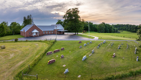 Death and funeral concept. American church cemetery with rows of tombstones on green grass in small townの写真素材