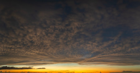 Getting dark at sundown. Sunset sky with scattered clouds of bright colorsの写真素材
