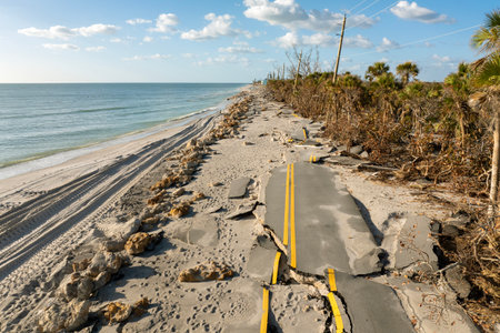 Hurricane storm surge destroyed waterfront road on ocean shore in Florida. Severe damage to transportation infrastructureの写真素材