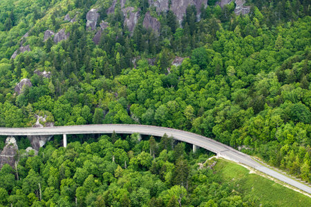 Mountain pass road in North Carolina Appalachian mountains, USA. Linn Cove Viaduct on Blue Ridge Parkway in summer rain seasonの写真素材