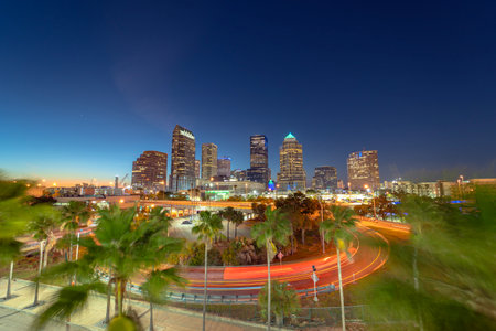Tampa, Florida. Cars traffic driving on wide highway and high skyscraper buildings in downtown district. American city with business financial district at nightfall.の写真素材