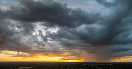 Tropical storm in Florida at sunset. Stormy clouds forming during heavy thunderstorm on dark sky. Moving and changing cloudscape weatherの写真素材