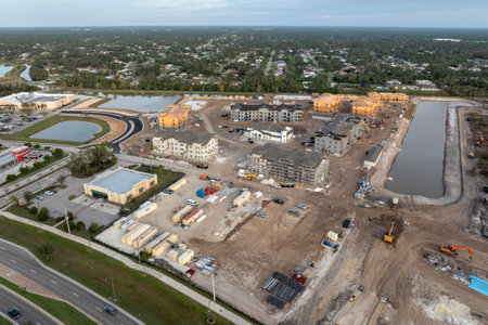 Unfinished frames of apartment condos with wooden roofs under construction. Development of residential housing in US suburbs. Real estate market in the USAの写真素材