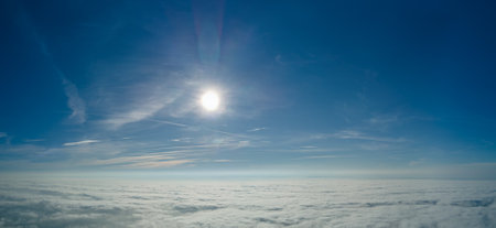 Aerial view from high altitude of earth covered with white puffy cumulus clouds on sunny dayの写真素材