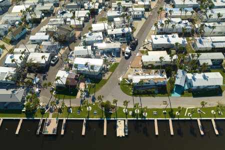 Severely damaged houses after hurricane Ian in Florida mobile home residential area. Consequences of...
