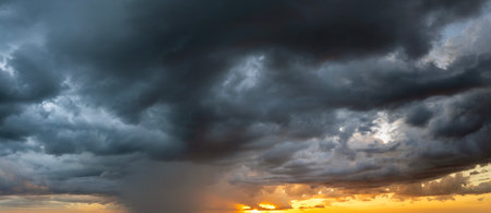 Stormy cumulus clouds forming during heavy thunderstorm on dark evening sky. Moving and changing cloudscape weatherの写真素材