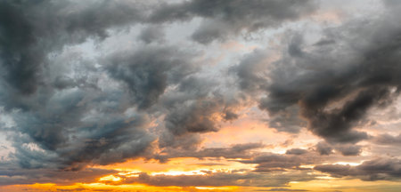 Sunset sky with bright colorful orange and yellow clouds. Panoramic skyscapeの写真素材
