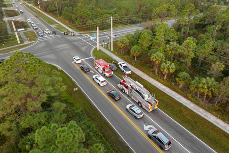 Traffic accident on American street in Florida. First responders helping victims of car crash on road in USA. Aerial view of emergency services responding to accident siteの写真素材