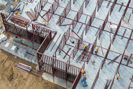 Development of commercial housing in USA. Construction works on monolithic frame. Large building site with scattered workers and equipment. Real estate marketの写真素材