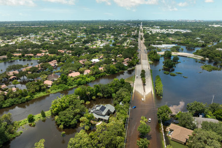 Flooded road with sunken car in surrounded with water Florida residential area. Consequences of hurricane Debby natural disasterの写真素材